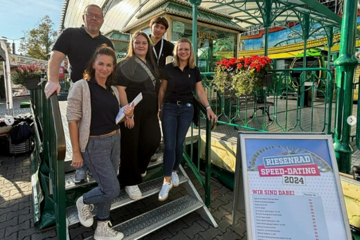 drei Frauen und zwei Männer stehen auf einer Stahltreppe im freien